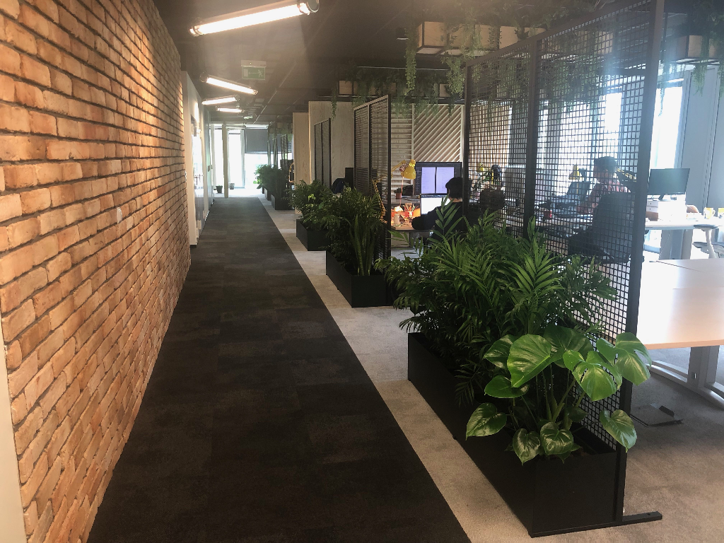 Biuro z roślinami i ceglaną ścianą.
