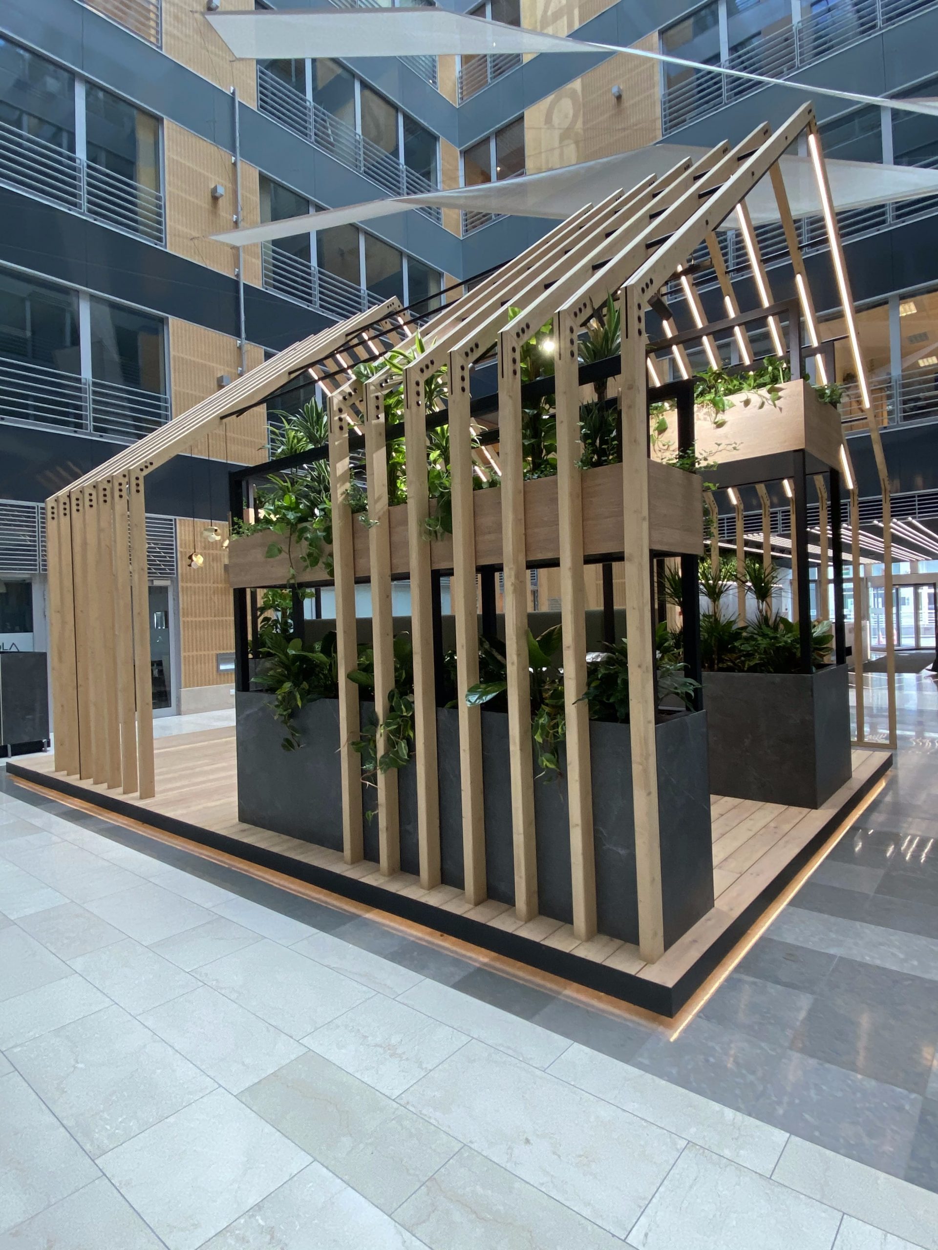 Drewniana konstrukcja z roślinami w budynku biurowym.