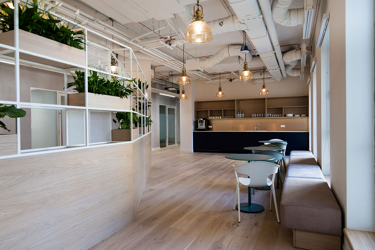 Nowoczesne biuro z drewnianymi podłogami i roślinami.