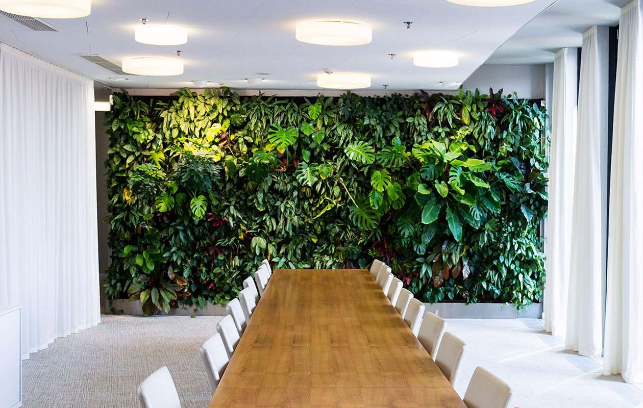 Sala konferencyjna z dużą ścianą roślin.